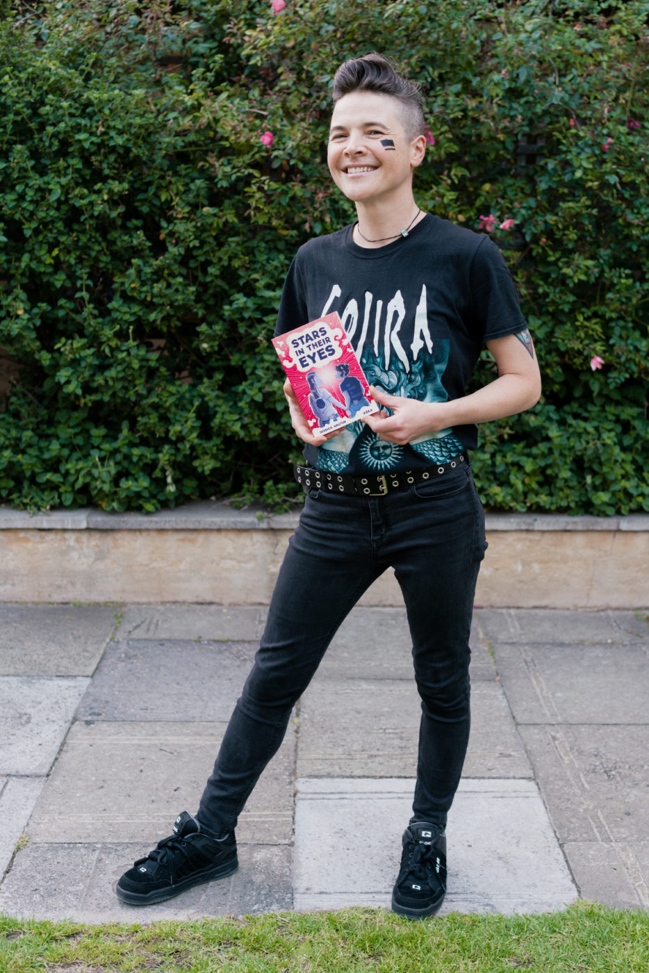 Aśka, illustrator of Stars in Their Eyes, proudly holding her book.