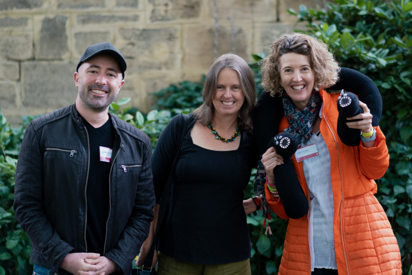 Authors James Foley, Meg McKinlay and Cristy Burne smiling at the camera with a stuffed metre long cotton shaped leach around Cristy's neck.