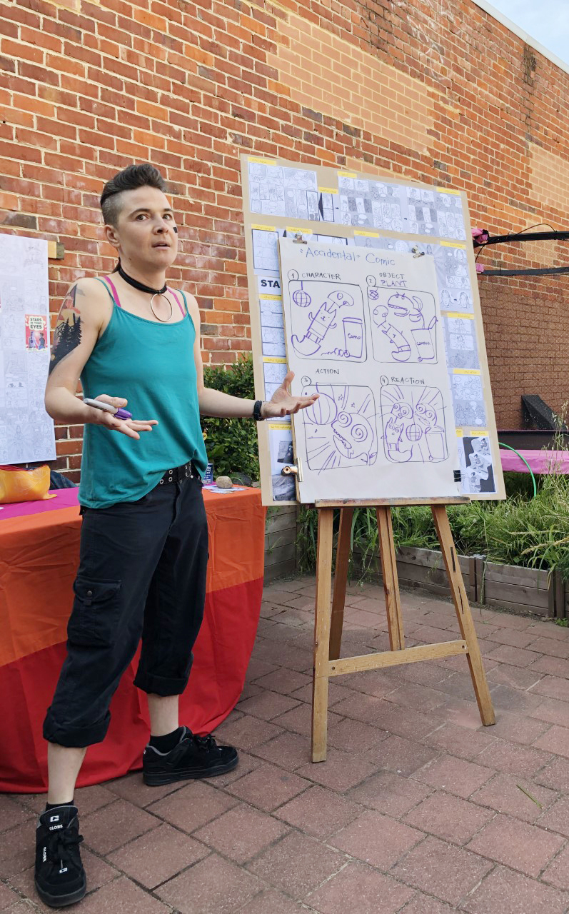 Image of a woman standing in front of an easel gesturing with her hands