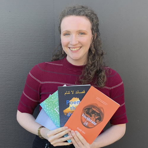 A smiley Kirsty Horton fans out poetry books like Vociferate